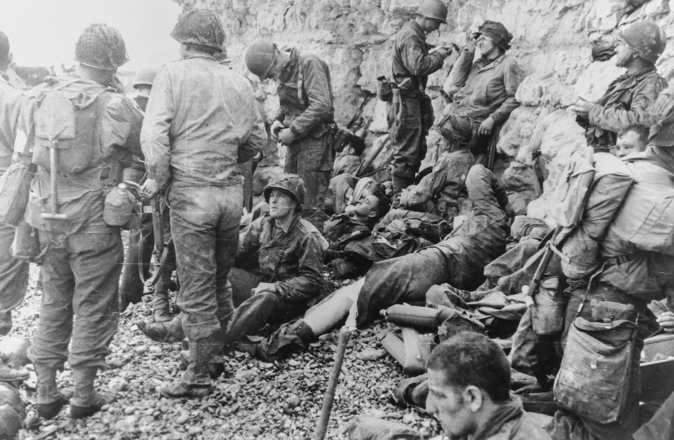 Assault troops of the 3rd Battalion, 16th RCT, from the first two waves, shelter under the chalk cliffs